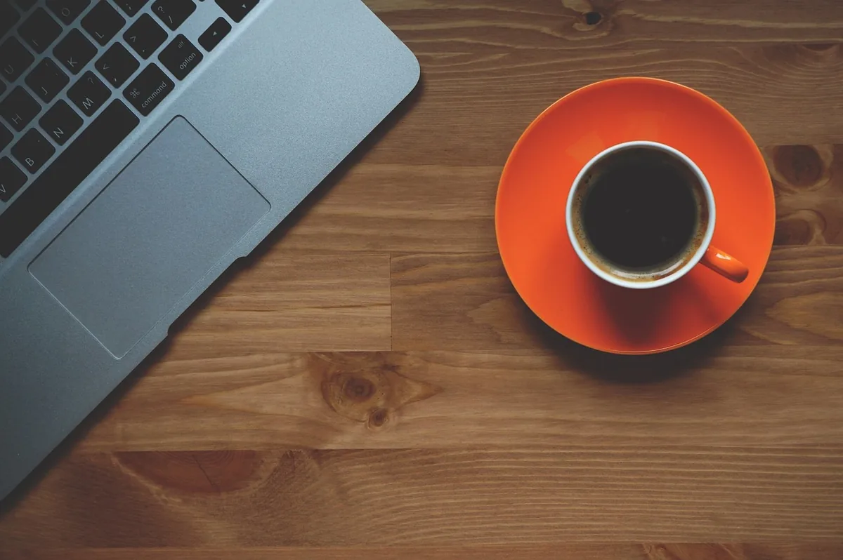 Xícara de café ao lado do notebook no escritório